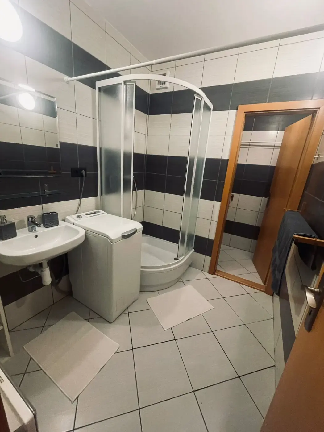 Kúpeľňa so sprchovým kútom, umývadlom a práčkou