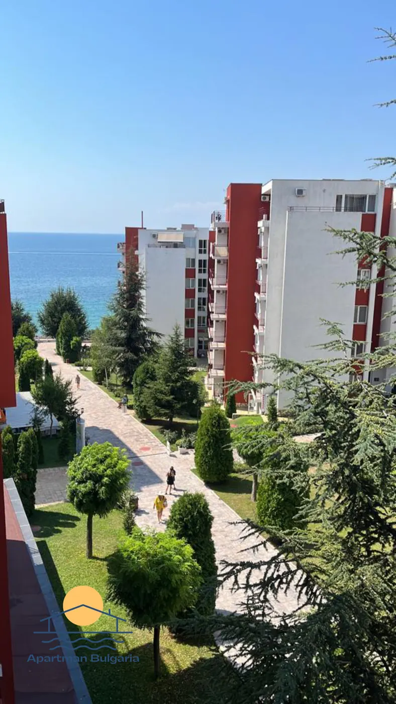 Pohľad z bytu na aleju medzi domami rezortu a na more za nimi